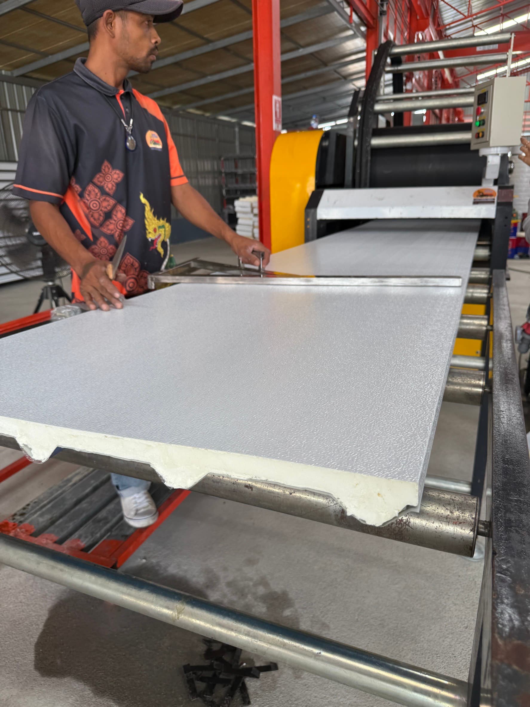Worker inspecting the foam core edge of a finished panel
